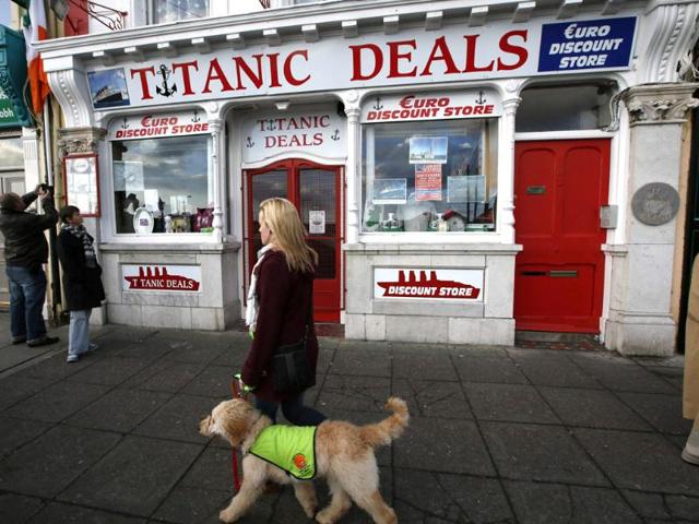 A woman passes the Titanic discount shop in Cobh. (Reuters/Chris Helgren)