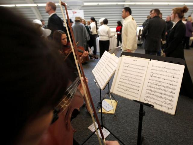 A band plays the tune 'Viceroy Tea' as passengers queue to check in for the MS Balmoral Titanic memorial cruise in Southampton, England.(AP Photo/Alastair Grant)