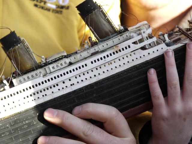Girl, holding a model of the Titanic, poses for pictures with Lload Walsh, as they wait to greet the disembarking passengers of the MS Balmoral Titanic memorial cruise ship at its first stop in Cobh, Ireland. (AP Photo/Lefteris Pitarakis)