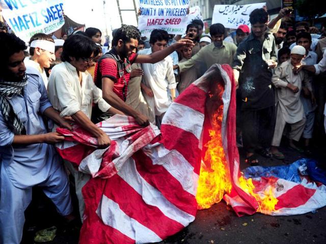 Pakistani religious students of Muttahida Talba Mahaz, set fire to a US flag during a protest rally in Karachi. Protesters condemned a $10 million bounty slapped on the founder of a terror group. The Defence Council of Pakistan, an alliance of right-wing, religious and extremist groups, organised the rallies to denounce the move against Hafiz Saeed, whose Lashkar-e-Taiba group was blamed for the 2008 Mumbai attacks in India.(AFP Photo)