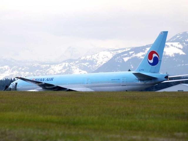A Korean Air Boeing 777 is parked on the runway of a Canadian Forces base in Comox, British Columbia after an emergency landing. The plane, en route from Vancouver, British Columbia to Seoul, diverted to Comox on Vancouver Island under escort by two US fighter jets after the airline's US call center received a call about a threat on board. (AP Photo/The Canadian Press, Richard Warrington)