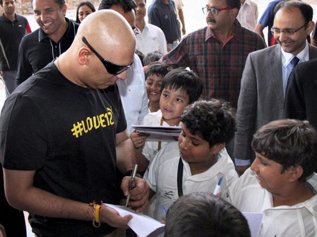 Cricketer Yuvraj Singh signs autograph for young fans after addressing a press conference in Gurgaon. (PTI Photo)