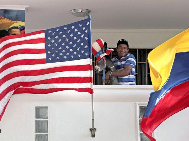 Silvio Carrasquilla poses with his baby donkey Demo, which he dressed as the mascot of the US Democratic Party, as he stands between the US and the Colombian flags, at his home in Turbaco, near Cartagena. Carrasquilla, Turbaco's former mayor who considers himself Colombia's number one Obama fan, is sprucing up his house by painting it the red, white and blue of the US flag to celebrate Obama's arrival in Cartagena for the VI Summit of the Americas. Reuters/Joaquin Sarmiento