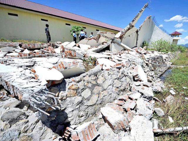 Officials of the Banda Aceh prison examine the damage to a wall a day after a powerful earthquake hit the west coast of Indonesia. AFP/Adek Berry