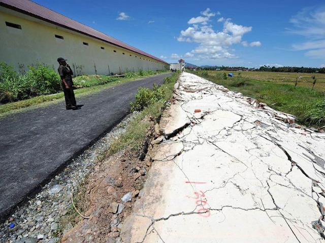 An official of the Banda Aceh prison examines the damage a day after a powerful earthquake hit the west coast of Indonesia. AFP/Adek Berry