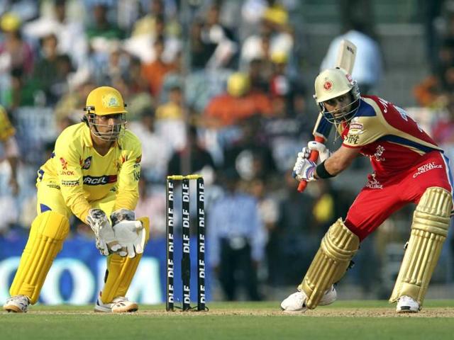 Royal Challengers Bangalore batsman Virat Kohli plays a shot while watched by Chennai Super Kings' Mahendra Singh Dhoni during the IPL Twenty20 cricket match between Chennai Super Kings and Royal Challengers Bangalore at The M.A. Chidambaram Stadium in Chennai. AFP Photo/Seshadri Sukumar