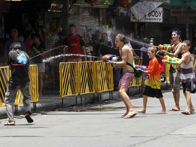 Tourists use water guns as they participate in a water fight with a local Thai during the Songkran Festival celebration at Khaosan road in Bangkok. The Songkran festival, also known as the water festival, marks the start of Thailand's traditional New Year and is believed to wash away bad luck. REUTERS/Chaiwat Subprasom