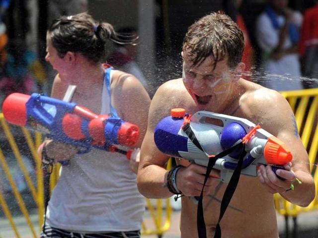 Tourists take part in watergun battles during the Songkran Festival along the famous travellers' area of Khao San Road in Bangkok. Songkran is the Thai New Year which starts on April 13 this year during which people celebrate by splashing water at each other. AFP PHOTO / PORNCHAI KITTIWONGSAKUL