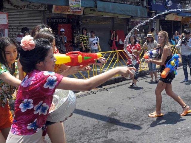 Thai teenagers enjoy a water battle with tourists during the Songkran Festival along the famous travellers' area of Khao San Road in Bangkok. Songkran is the Thai New Year which starts on April 13 this year during which people celebrate by splashing water at each other. AFP PHOTO / PORNCHAI KITTIWONGSAKUL