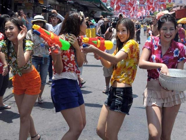Thai teenagers enjoy a water battle with tourists during the Songkran Festival along the famous travellers' area of Khao San Road in Bangkok. Songkran is the Thai New Year which starts on April 13 this year during which people celebrate by splashing water at each other. AFP PHOTO / PORNCHAI KITTIWONGSAKUL