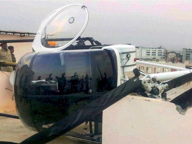 The helicopter of Hindustan Aeronautics Limited which made an emergency landing on the roof of an apartment in Byapanahalli area in Bengaluru. Both the pilot and the co-pilot escaped unhurt, police said. (PTI Photo)