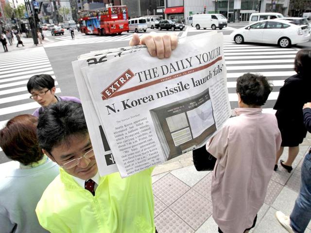 A newspaper employee shows an extra issue of the Daily Yomiuri reporting North Korea's rocket launch to hand over to passers-by in Tokyo. AP Photo/Itsuo Inouye