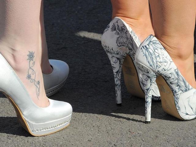 A woman shows off her tattoo and high-heeled shoes during the second day of the Grand National horse racing meeting at Aintree Racecourse in Liverpool, north-west England. AFP Photo/Andrew Yates