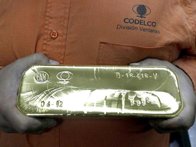 A worker shows an ingot of 99.99% pure gold that weighs 12.5 kg (28 lbs), inside the noble metals plant on the copper refinery of Codelco Ventanas in Ventanas city, near Santiago. In Ventanas plant gold bars are manually poured into molds, instead of using more modern mechanized methods, according to company sources. Reuters photo/Eliseo Fernandez