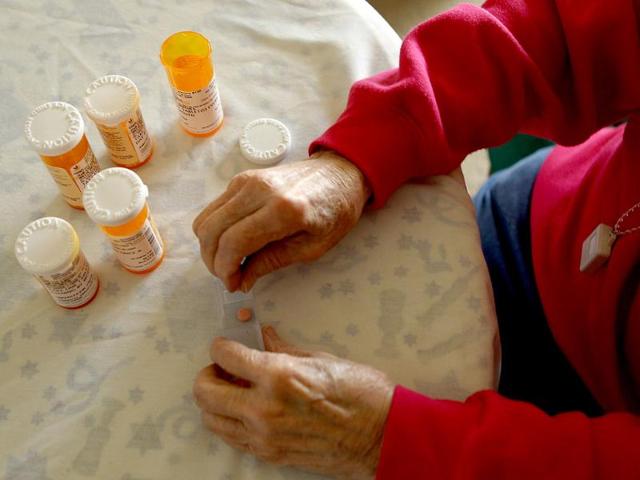 Inez Willis, a senior citizen, sorts her daily medical prescriptions at her independent living apartment in Silver Spring, Maryland. Reuters/Gary Cameron