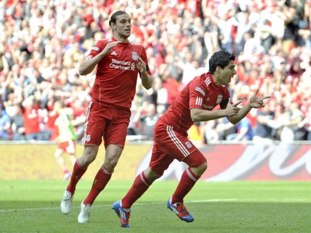 Liverpool's Luis Suarez (R) celebrates his goal against Everton with teammate Andy Carroll during their English FA Cup semifinal soccer match at Wembley Stadium in London. AP Photo/Tom Hevezi