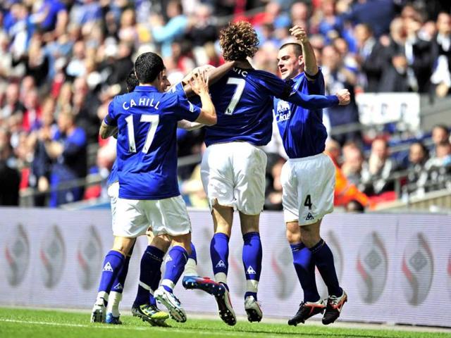 Everton striker Nikica Jelavic (2nd R) celebrates scoring the opening goal with teammates during the FA Cup semifinal football match against Liverpool at Wembley Stadium in London, England. AFP Photo/Glyn Kirk