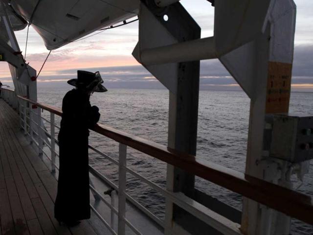 Helena Beaumont-Jones of Airlie Beach, Australia, who is affected by grief, views the passing sea at sunset as the Titanic Memorial Cruise continues to the Titanic disaster site for a memorial service in the western Atlantic Ocean. (Reuters/Chris Helgren)