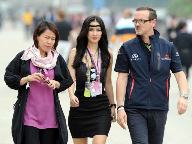 Celina Jade is escorted by a Red Bull team official in the paddock area before the start of the Chinese Grand Prix in Shanghai. AFP Photo