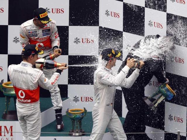Nico Rosberg of Germany, McLaren driver Jenson Button (L) of Britain and his teammate and compatriot Lewis Hamilton shower Mercedes head of motorsport Norbert Haug with champagne after winning the Chinese Grand Prix in Shanghai. (AP Photo/Mark Baker)