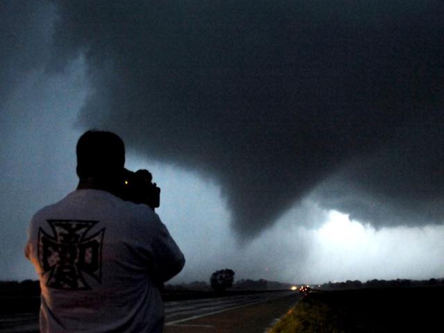 Storm chaser photographer Brad Mack shoots a tornado as it makes its way over the 135 freeway near Moundridge, Kansas, during the third day of severe weather and multiple tornado sightings. A spate of tornadoes tore through parts of Oklahoma, Kansas, Nebraska and Iowa, churning through Wichita and other areas, causing widespread damage and killing two. REUTERS/Gene Blevins