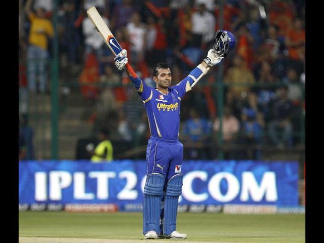 Rajasthan Royals batsman Ajinkya Rahane raises his bat and helmet to celebrate scoring a century during their Indian Premier League (IPL) cricket match against Royal Challengers Bangalore in Bangalore. AP/Aijaz Rahi