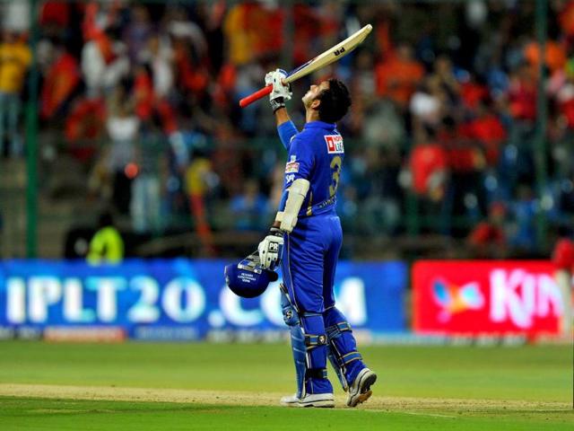 Rajasthan Royals batsman Ajinkya Rahane raises his bat to celebrate the first century of IPL 5 during the Twenty20 cricket match against Royal Challengers Bangalore at the M Chinnaswamy Stadium in Bangalore. AFP/Manjunath Kiran