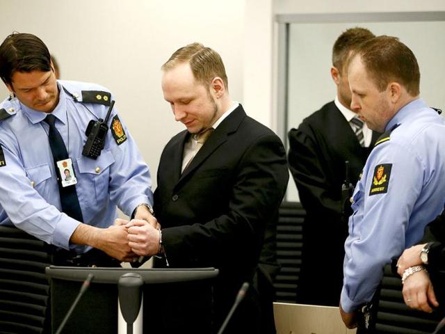 Defendant Norwegian mass killer Anders Behring Breivik (C) has his handcuffs removed after arriving for his trial in a courtroom in Oslo. Reuters/Fabrizio Bensch