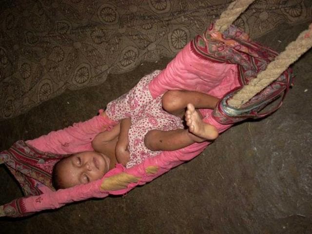 A severely malnourished child lies unattended at Ektai village. Her parents work in the fields the entire day.