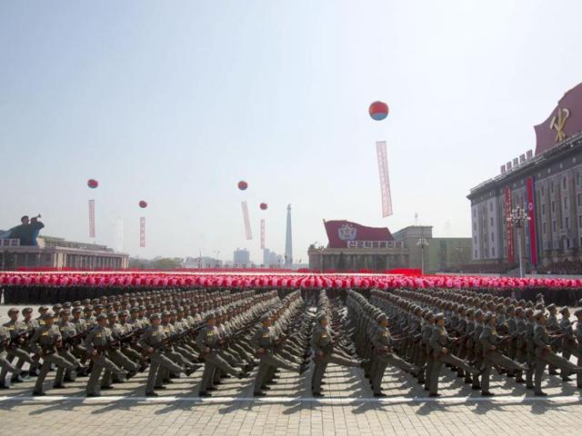 North Korean soldiers march in front of flower waving civilians during a mass military parade in Pyongyang's Kim Il Sung Square to celebrate 100 years since the birth of North Korean founder Kim Il Sung. (AP Photo/David Guttenfelder)