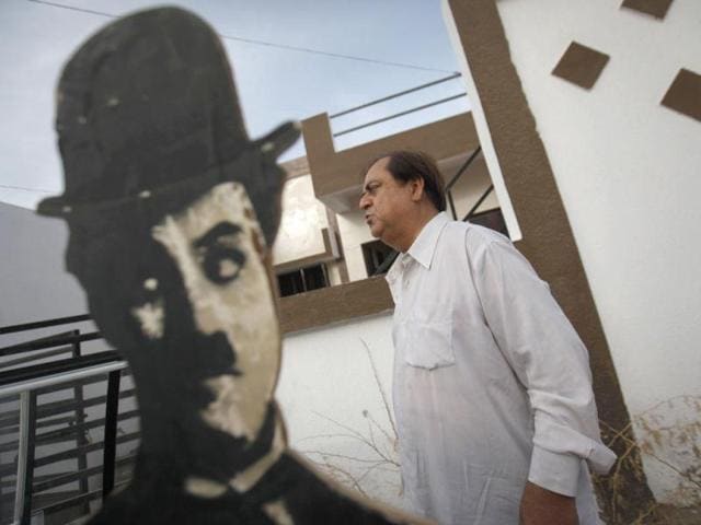 Ashok Aswani poses with a cut-out picture of Charlie Chaplin inside a studio in Adipur. (Reuters/Danish Siddiqui)