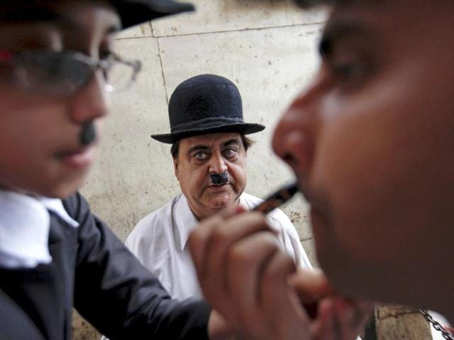 Ashok Aswani watches as a member of his club has his make-up applied before celebrations marking Charlie Chaplin's birthday in Adipur in Gujarat. (Reuters/Danish Siddiqui)