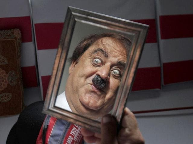 Ashok Aswani, a 63-year-old doctor gestures as he gets dressed up as Charlie Chaplin in his house in Adipur. (Reuters/Danish Siddiqui)