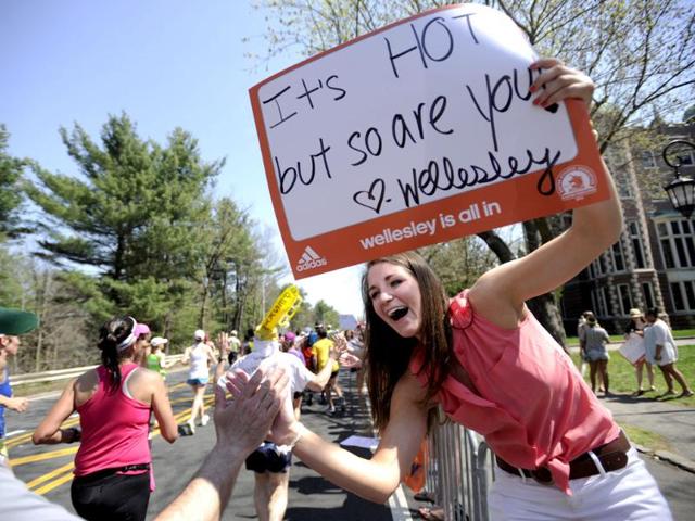 Wellesley College Sophomore Valerie Ludorf, of Hopkinton, cheers for the runners along the route of the 116th Boston Marathon in Wellesley, Massachusetts. (Reuters/Gretchen Ertl)