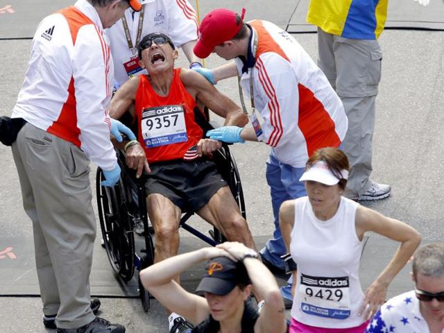 John Ouweleen is helped into a wheelchair and attended to by medical staff after crossing the finish line of the 116th Boston Marathon in Boston, Massachusetts. (Reuters/Jessica Rinaldi)