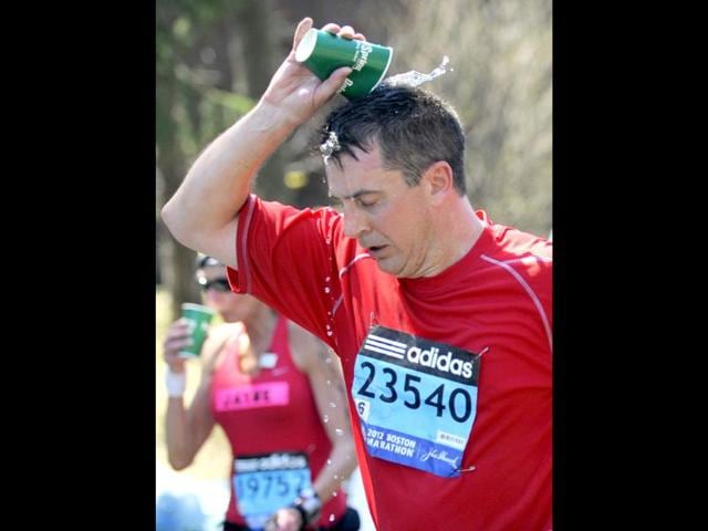 A runner douses himself with water along the route of the 116th Boston Marathon in Wellesley, Massachusetts. (Reuters/Gretchen Ertl)