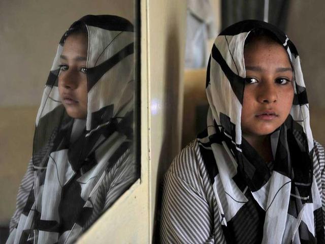 Eleven year old Afghan girl Tarana Akbari, poses after an interview at her home in Kabul. The "girl in the green dress", subject of AFP photographer Massoud Hossaini's Pulitzer-winning photograph, still has nightmares about the day a suicide bomber made her image world famous. AFP/Shah Marai