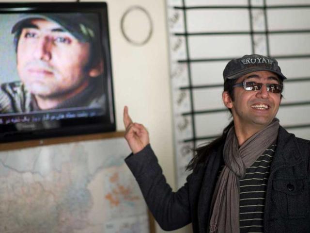 Massoud Hossaini reacts as he sees his photograph reproduced on Afghan television at the AFP office in Kabul. Hossaini won the Pulitzer award for breaking news photography "for his heartbreaking image of a girl crying in fear after a suicide bomber's attack at a crowded shrine in Kabul". AFP/Johannes Eisele