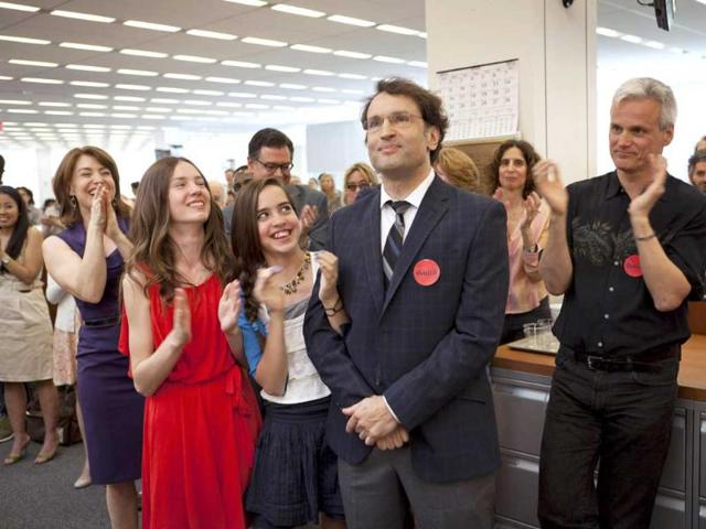 Reporter David Kocieniewski (C) receives a round of applause next to his girlfriend and daughters, during a celebration for Pulitzer Prize winners in the New York Times newsroom in New York Kocieniewski won the Pulitzer in explanatory reporting for his series on how some of the United States' wealthiest citizens and corporations exploited loopholes and avoided taxes. Reuters/Richard Perry/NYT handout
