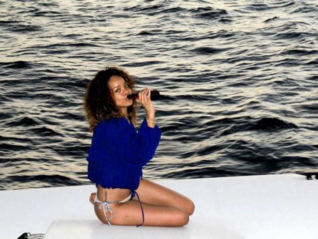 Rihanna enjoys a bottle of drink.