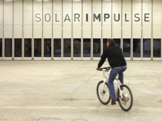A staff member rides a bike in the Solar Impulse's solar-powered HB-SIA prototype airplane hangar at Payerne airport. The Solar Impulse HB-SIA, which has 12,000 solar cells built into its 64.3-meter (193-foot) wings, is a prototype for an aircraft that its creators hope will carry out its first circumnavigation of the globe from 2012. Reuters/Denis Balibouse