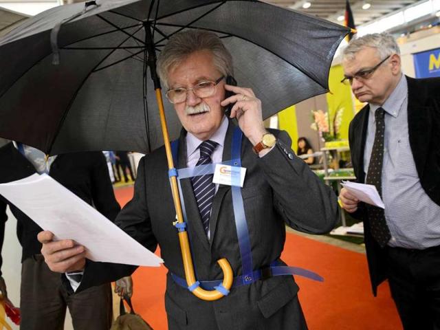 Italy's Marco Pagnini presents his invention, a suspender for carrying an umbrella without using hands. AFP/Fabrice Coffrini