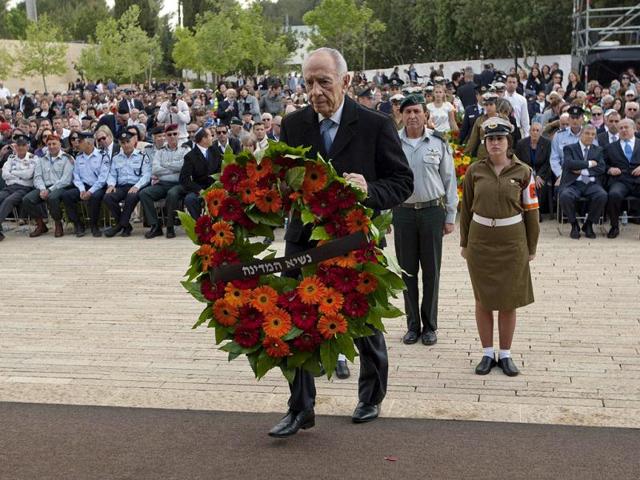 Israelis President Shimon Peres attends a wreath-laying ceremony during an annual ritual on Holocaust Memorial Day at the Yad Vashem Holocaust Memorial in memory of the six million Jews who perished, in Jerusalem. AFP Photo/Pool/Ariel Schalit
