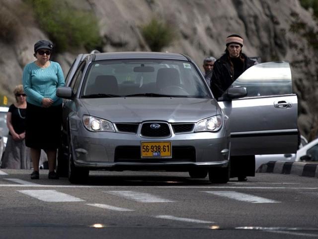 Israelis stand still next to their cars on a highway as a two-minute siren sounds in memory of victims of the Holocaust in Jerusalem. AP Photo/Sebastian Scheiner