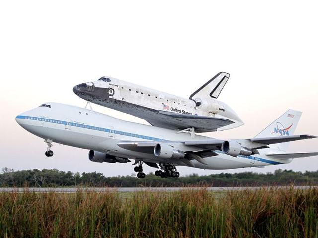 Space shuttle Discovery atop a 747 carrier jet departs the Kennedy Space Center in Cape Canaveral. (AP Photo/John Raoux)
