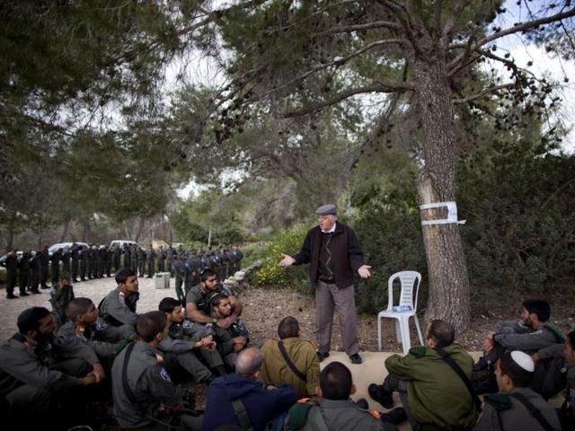 A Holocaust survivor tells his personal testimony to Israeli border police officers during a ceremony marking the annual Holocaust remembrance day a in the Martyr's forest near Moshav Kesalon, in central Israel. AP Photo/Oded Balilty