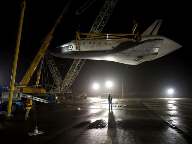 This NASA photo shows the space shuttle Discovery suspended from a sling held by two cranes as the NASA 747 Shuttle Carrier Aircraft (SCA) was pushed back from underneath at Washington Dulles International Airport in Sterling, Virginia. (AFP Photo)