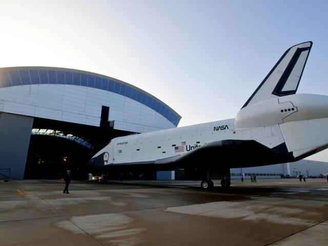 In this photo provided by NASA, space shuttle Enterprise rolls from the space hangar at the Steven F Udvar-Hazy Center prior to a transfer ceremony in Chantilly. (AP Photo/NASA)