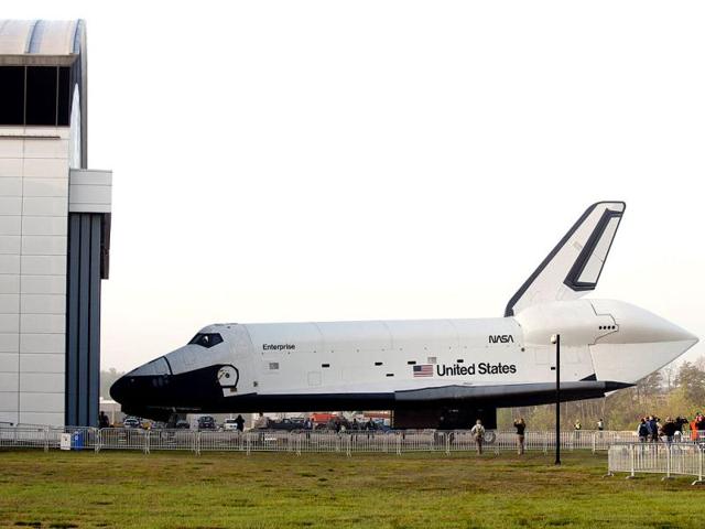 The Space Shuttle Enterprise moves out of the Space hangar at the Smithsonian National Air and Space Museum Steven F. Udvar-Hazy Center in Chantilly, Virginia, prior to a ceremony where Space Shuttle Discovery will be officially received by the museum and placed on permanent display. (AFP PHOTO)