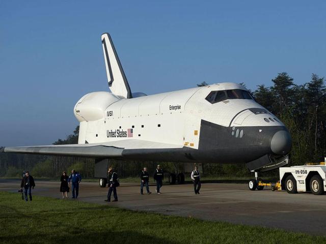 The Space Shuttle Enterprise is towed from the Space hangar at the Smithsonian National Air and Space Museum Steven F Udvar-Hazy Center in Chantilly, Virginia, prior to a ceremony where Space Shuttle Discovery will be officially received by the museum and placed on permanent display. Discovery is the first spaceship of the retired US shuttle fleet to enter its permanent home as a museum artifact, replacing the prototype Enterprise, which will be moved to a museum in New York. (AFP Photo)